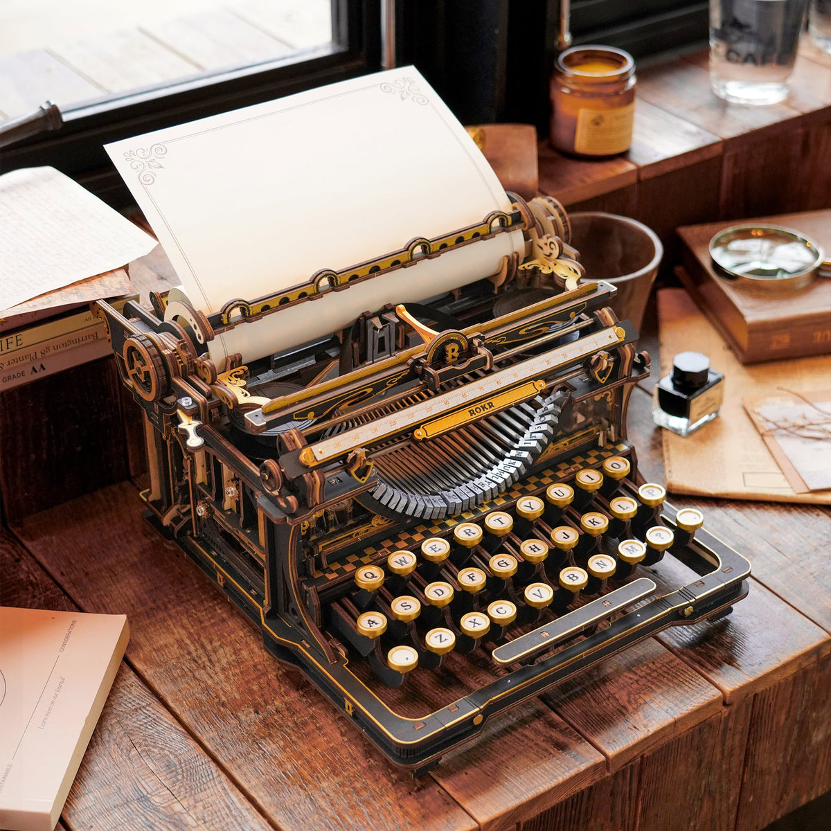 Assembled wooden typewriter on a writing desk for scale
